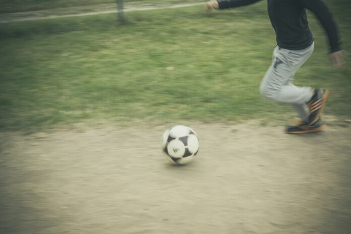 Ein Kind spielt Fußball auf einem Bolzplatz. Foto: pixabay