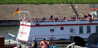 Spaziergänger genießen in Duisburg Ruhrort Sonnenstrahlen am Ufer des Vinckekanals.