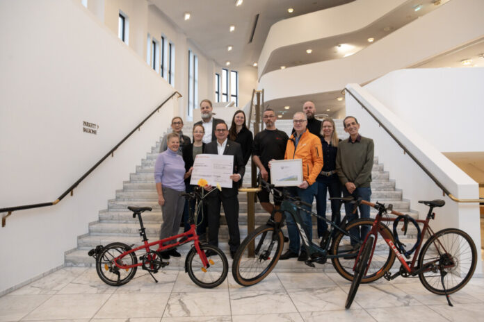 Im Foyer des Aalto-Theaters erhielt die Theater und Philharmonie Essen (TUP) am Montag, 11. November 2024 vom Allgemeinen Deutschen Fahrrad-Club die Auszeichnung „Fahrradfreundlicher Arbeitgeber“. Die Zertifizierung wird von der Grünen Hauptstadt Agentur der Stadt Essen finanziell gefördert. Oberbürgermeister Thomas Kufen überreichte dazu einen symbolischen Scheck von 1.500 Euro an TUP-Geschäftsführer Fritz Frömming. Foto: TUP/Caroline Schlüter