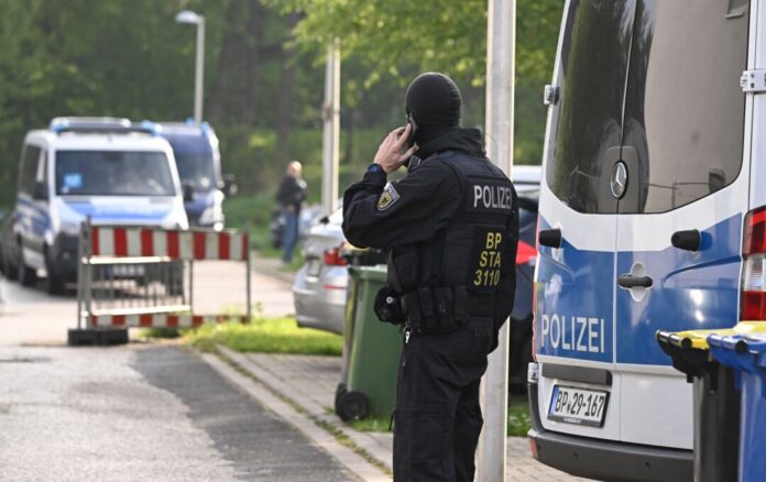 Ein Polizist steht im Rahmen einer Razzia gegen Schleuser vor einem Auto. (Archivfoto)