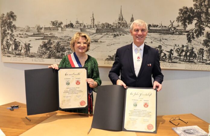 Bürgermeisterin Marie-Sophie Lesne und Bürgermeister Klaus Pesch präsentieren die frisch unterzeichneten Urkunden zur Bekräftigung der Partnerschaft zwischen Le Quesnoy und Ratingen. Foto: Stadt Ratingen