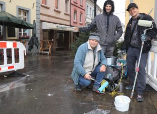 Die drei Künstler Alex Weigandt, Jaroslaw Masztalerz und Gregor Wosik (von rechts nach links) hoffen in den nächsten Tagen auf trockenes Wetter, um das provisorische Pflaster zügig künstlerisch zu gestalten. Foto: Stadt Ratingen