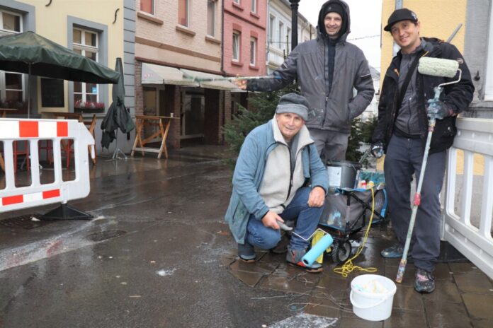 Die drei Künstler Alex Weigandt, Jaroslaw Masztalerz und Gregor Wosik (von rechts nach links) hoffen in den nächsten Tagen auf trockenes Wetter, um das provisorische Pflaster zügig künstlerisch zu gestalten. Foto: Stadt Ratingen