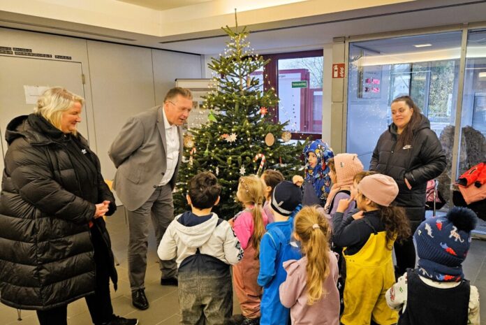 Die Kinder des Familienzentrums Ellenbeek haben die Tanne im Rathaus geschmückt. Wülfraths Bürgermeister Rainer Ritsche freut sich über den Besuch. Foto: Stadt Wülfrath