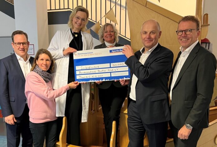 Andreas Lösing (2. v. r.), Vorstandsvorsitzender der Sparda-Bank West, überreichte zusammen mit Dominik Schlarmann (rechts), stellvertretender Vorstandsvorsitzender, und Vorstand Sebastian Schöpper (links) einen symbolischen Scheck an Marita Grimm (3. v. r.), Geschäftsführerin des Bundesverbandes Bunter Kreis e.V., Dr. Britta Hüning (3. v. l.), ärztliche Leitung der Nachsorgeeinrichtung in Essen und Vorstandsmitglied des Bundesverbandes, und Simone Leibold (2. v. l.), stellvertretende pflegerische Leitung der Essener Nachsorgeeinrichtung der Essener Einrichtung. Foto: Sparda-Bank West