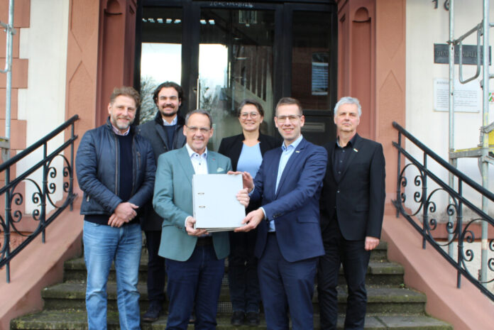 Bürgermeister Christoph Schultz (vorne rechts) übereicht an CatellaGeschäftsführer Klaus Franken (vorne links) die Baugenehmigung zur Realisierung der „Düssel-Terassen“ am Wimmersberg in Alt-Erkrath. Foto: Stadt Erkrath