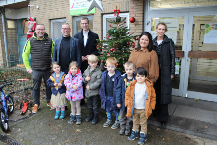 Tobias Wagemann (1.v.l.), Andre Kowalczyk (2.v.l.) und seine Kollegin Nicole Zarenkow (1.v.r.) spendeten auch 2024 wieder Tannenbäume an die Erkrather Kitas. Die Kinder der Kita Unterfeldhaus freuten sich gemeinsam mit der stellvertretenden Kita-Leiterin Zümrüt Maibach (2.v.r.) und Bürgermeister Christoph Schultz (3.v.l.) über den Weihnachtsgruß. Foto: Stadt Erkrath
