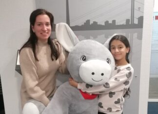 Jasmin hat den Malwettbewerb der Kreissparkasse gewonnen und erhält den XXL-Esel Olli von Christina Biedebach (Kreissparkasse Düsseldorf). Foto: Sparkasse