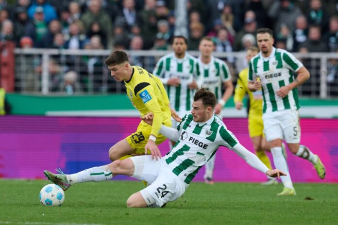 Münsters Niko Koulis verhindert eine Chance des Ulmers Semir Telalovic (l).