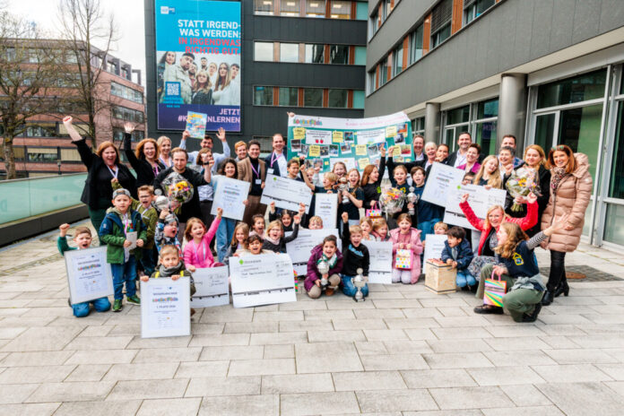 Nach der Preisverleihung kamen alle „LogistiKids“-Gewinner aus dem Kindergarten- und Grundschulbereich zum Gruppenfoto zusammen. Den Siegerpokal für das Familienzentrum Erfurter Straße hält die kleine Lawin (mittig, lila Jacke) in den Händen. Foto: IHK Essen/Alexey Muchrik