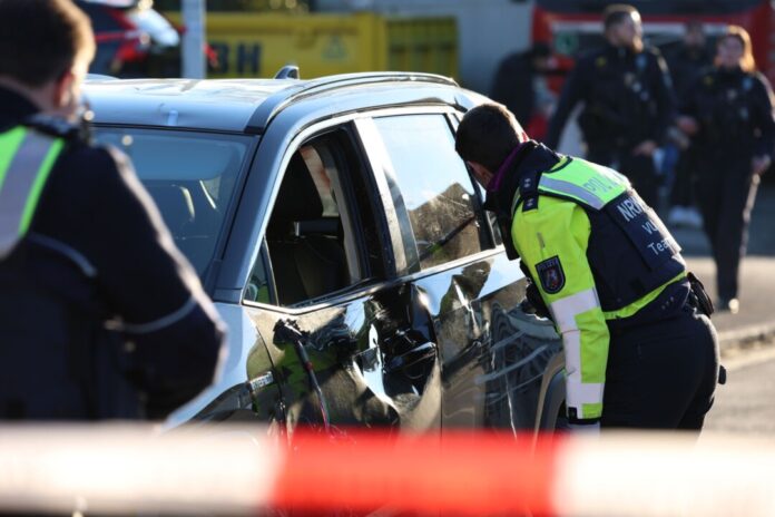 Einsatzkräfte untersuchen nach dem Unfall ein Fahrzeug.