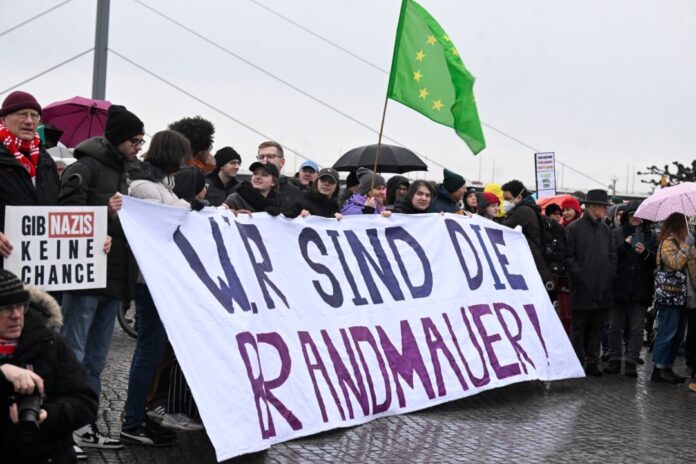 Demonstranten in Düsseldorf protestieren gegen die aktuelle CDU-Migrationspolitik.