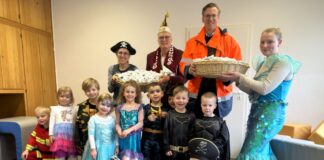 Gabor Lang, Werksleiter des Lhoist-Kalkwerks Flandersbach überreicht einen Teil der Rosenmontags-Süßigkeiten an die Kinder der evangelischen Kita Rohdenhaus und ihre Erzieherinnen sowie an den Vorsitzenden der Kalkstadt Narren Wülfrath, Andreas Schulz. Foto: Lhoist