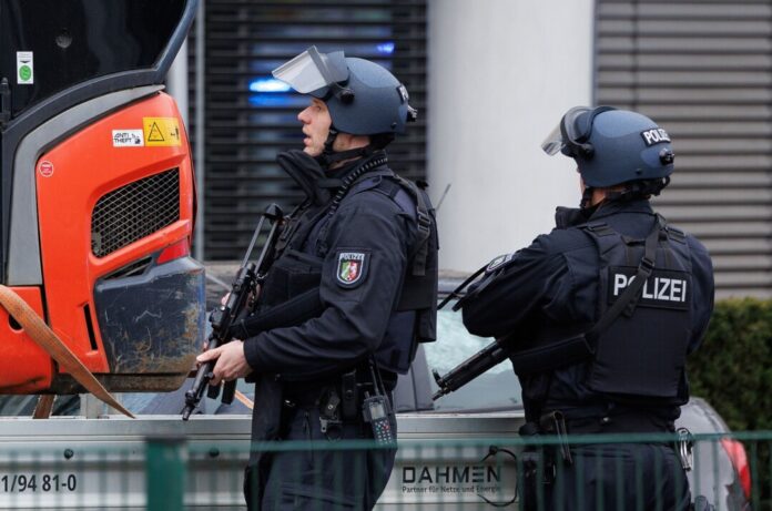 Schwer bewaffnet und geschützt: Nach den Schüssen sind auch zahlreiche Polizisten vor Ort