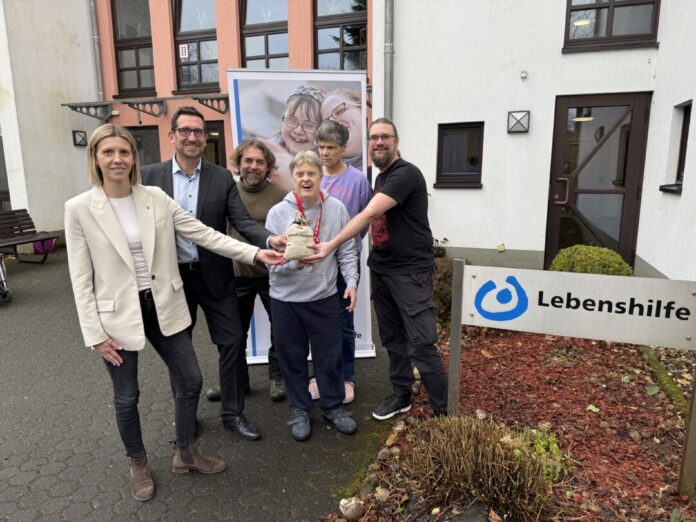 Legut, Dezernentin für Jugend, Soziales und Kultur im Rathaus Heiligenhaus, Thomas Meuser, Gebietsdirektor der Kreissparkasse Düsseldorf, und Musiker Hannes Johannsen übergeben die Spende an die Bewohner Christian Schnecke und Heike Steinig sowie Wohnhaus-Leiter Christian Hitzbleck. Foto: Sparkasse