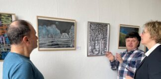 Bürgermeisterin Sandra Pietschmann, Michalis Papadopoulos (l.) und Orest Smishko, ein Freund der Künstler, schauen sich Bilder von Alexander Bondartschuk an. Foto: Kreisstadt Mettmann