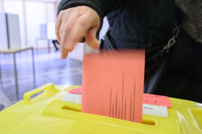 Eine Frau wirft ihren Wahlzettel für die Bundestagswahl 2025 in der Briefwahlstelle in eine Urne. (Archivbild)