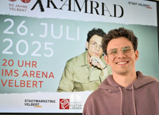Musiker Tim Kamrad vor Plakat