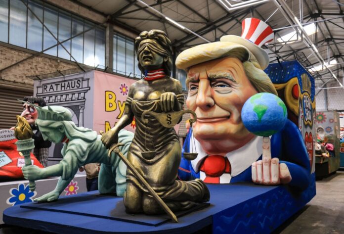 Einer der Wagen im Kölner Rosenmontagszug zeigt US-Präsident Donald Trump, der sich die Freiheitsstatue und die Justitia - Demokratie und Rechtsstaat - unterworfen hat. (Archivbild)