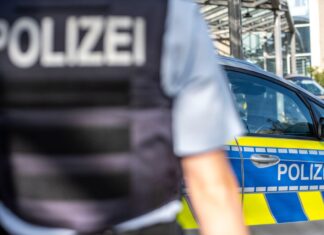 Ein Polizist steht vor einem Streifenwagen. Ermittler der Kriminalpolizei in Bielefeld haben nach einem Sexualdelikt einen Tatverdächtigen gefasst. (Symbolbild)