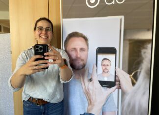 Giulia Tarentino mit einem neuen Smartphon, mit dem die Mitarbeiterinnen im Bürgerservice ab Mai Passbilder machen können. Rechts ein Aufsteller, der zeigt, wie es funktioniert. Foto: Kreisstadt Mettmann