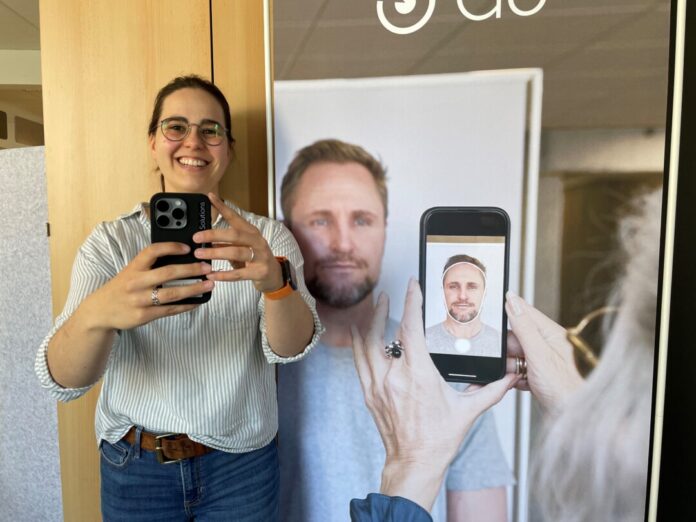 Passfotos mit dem Smartphone Giulia Tarentino mit einem neuen Smartphon, mit dem die Mitarbeiterinnen im Bürgerservice ab Mai Passbilder machen können. Rechts ein Aufsteller, der zeigt, wie es funktioniert. Foto: Kreisstadt Mettmann