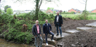 In Unterfeldhaus ermöglichen mehrere große Trittsteine eine Querung des Eselsbachs. Bürgermeister Christoph Schultz (M.) und Sven Wernke, Abteilungsleiter Straßen (l.), bedankten sich bei Engin Alparslan (r.) vom BRW für die gelungene Umsetzung. Foto: Stadt Erkrath