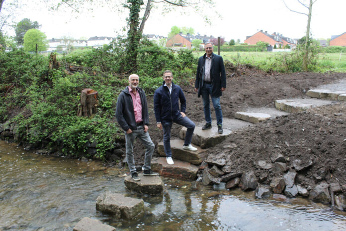 Trittsteine im Eselsbach In Unterfeldhaus ermöglichen mehrere große Trittsteine eine Querung des Eselsbachs. Bürgermeister Christoph Schultz (M.) und Sven Wernke, Abteilungsleiter Straßen (l.), bedankten sich bei Engin Alparslan (r.) vom BRW für die gelungene Umsetzung. Foto: Stadt Erkrath