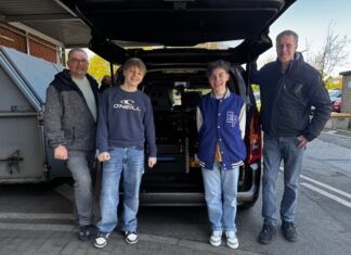 Axel Beck (l.) und Thorsten Corrinth (r.) von der Abteilung Verkehrssicherheit des Kreises Mettmann mit den Schülern Tom Markus Moissl (l.) und Santiago Gleißner (r.) vor einem mobilen Blitzer. Foto: Kreis Mettmann