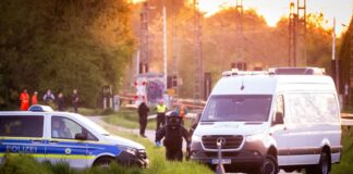 Einsatzkräfte der Polizei und der Entschärferdienst der Bundespolizei suchen nach einer Explosion die Bahngleise ab. 