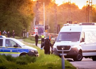 Einsatzkräfte der Polizei und der Entschärferdienst der Bundespolizei suchen nach einer Explosion die Bahngleise ab. 