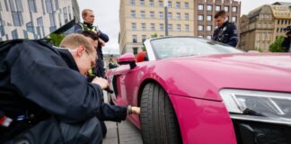 Polizeibeamte überprüfen am «Car-Freitag» ein Fahrzeug auf dem Corneliusplatz in Düsseldorf.