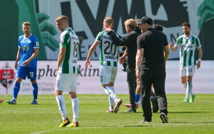 Münsters Trainer Sascha Hildmann geht nach dem Spiel über den Rasen.