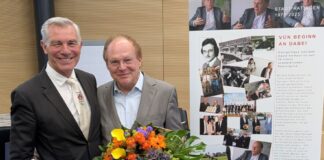 Als Geschenk zu seinem Jubiläum überreichte Bürgermeister Klaus Pesch seinem Stellvertreter Ewald Vielhaus ein Roll-up mit Stationen seiner langen politischen Laufbahn. Foto: Stadt Ratingen