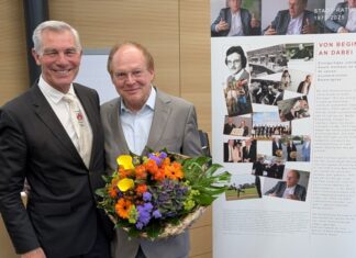Als Geschenk zu seinem Jubiläum überreichte Bürgermeister Klaus Pesch seinem Stellvertreter Ewald Vielhaus ein Roll-up mit Stationen seiner langen politischen Laufbahn. Foto: Stadt Ratingen