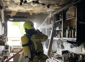 Ein Feuerwehrmann bei Löscharbeiten in der zerstören Küche. Foto: FW Ratingen