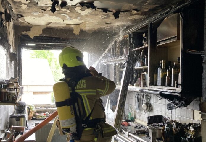 Ein Feuerwehrmann bei Löscharbeiten in der zerstören Küche. Foto: FW Ratingen