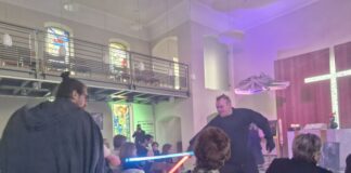 Star-Wars-Gottesdienst in Bensberg: Pfarrer Samuel Dörr (l) kämpft während des Gottesdienstes mit einem Gemeindemitglied einen Schwertkampf mit einem Laserschwert. 