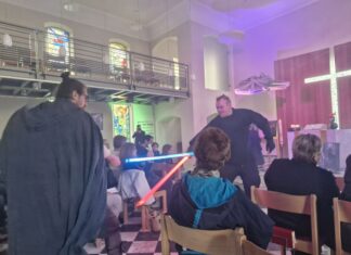 Star-Wars-Gottesdienst in Bensberg: Pfarrer Samuel Dörr (l) kämpft während des Gottesdienstes mit einem Gemeindemitglied einen Schwertkampf mit einem Laserschwert. 
