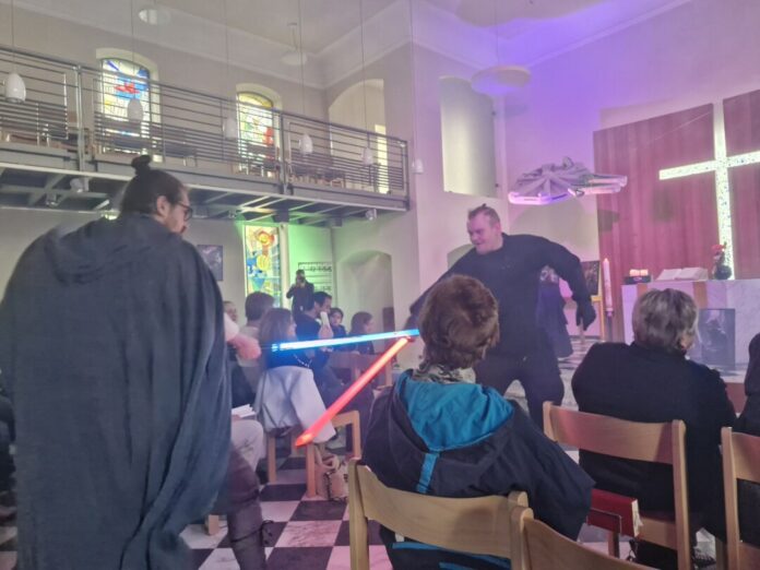 "Star Wars" Gottesdienst in Bensberg Star-Wars-Gottesdienst in Bensberg: Pfarrer Samuel Dörr (l) kämpft während des Gottesdienstes mit einem Gemeindemitglied einen Schwertkampf mit einem Laserschwert.
