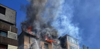 Feuerwehrleute retten eine Mutter mit ihrer Tochter aus dem brennenden Dachgeschoss. 
