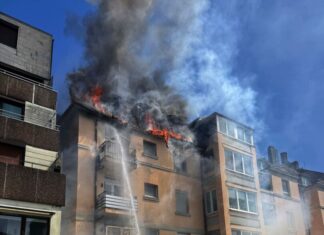 Feuerwehrleute retten eine Mutter mit ihrer Tochter aus dem brennenden Dachgeschoss. 