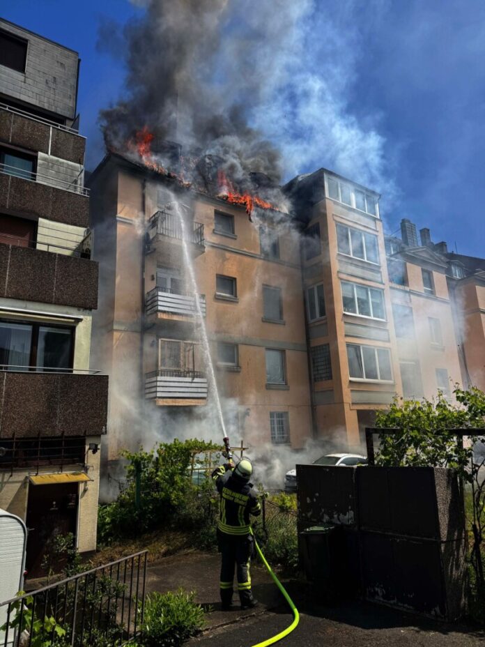 Feuerwehrleute retten eine Mutter mit ihrer Tochter aus dem brennenden Dachgeschoss. 