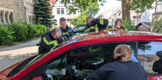 Feuerwehrleute schauen nach, wie es dem Mädchen in dem Auto geht. Es war bester Laune. 