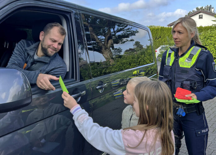 Foto2 Dieser Autofahrer hat alles richtig gemacht: Sabrina Berten von der Verkehrsunfallprävention übergibt mit Joshua und Madleen einen grünen "Dankzettel". Foto: Polizei