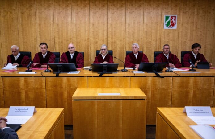 Sieben Verfassungsrichter sitzen bei der mündlichen Verhandlung am Richtertisch: in der Mitte die Präsidentin Barbara Dauner-Lieb.