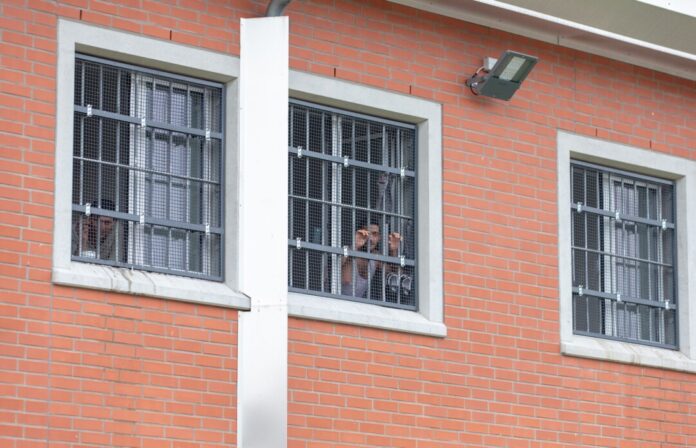 Insassen blicken durch vergitterte Fenster in der Unterbringungseinrichtung für Ausreisepflichtige in Büren (Archivfoto)