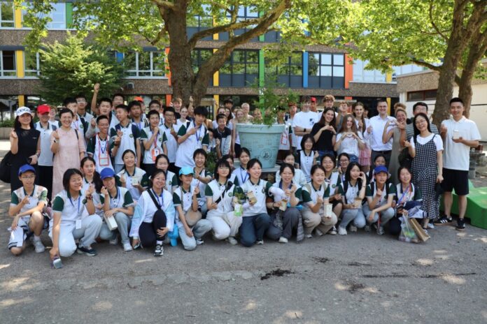 Chinesische und deutsche Schülerinnen und Schüler pflanzten gemeinsam den „Partnerschaftsbaum“ und unterschrieben auf dem Kübel. Foto: Stadt Ratingen