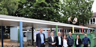 Der Schulhofgang an der Wilhelm-Busch-Schule wird abgerissen, um Platz für einen Ergänzungsanbau zu machen. Den Startschuss für diese Baumaßnahme verfolgten (von links nach rechts) Hochbaudezernent Martin Gentzsch, Erster Beigeordneter Patrick Anders, Geschäftsführer Stefan Zimmermann, Adreola Jaupi und Stefan Welling (beide Stabsstelle Hochbau), Sandra Hölzer-Schramm (Leiterin Schulverwaltungsamt) und Planer Gerrit Gramsch. Foto: Stadt Ratingen