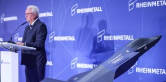Ein Modell des F-35 auf der Bühne, auf der Konzernchef Papperger zu Mitarbeitern spricht.